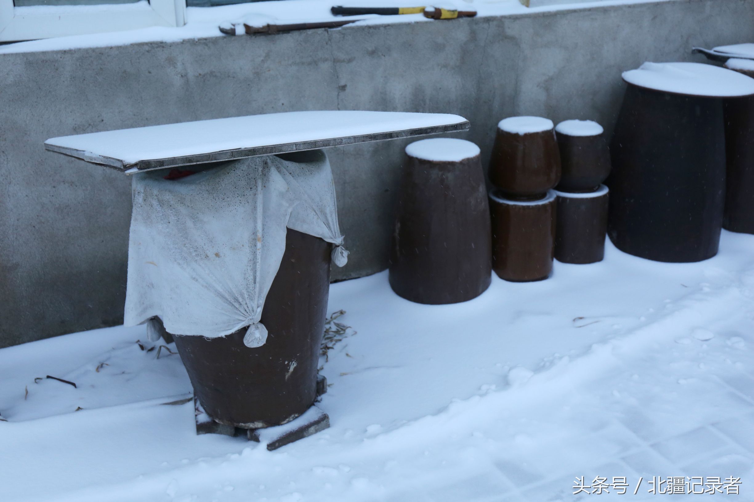 东北小屯子被白雪覆盖，宅基地有半晌地大，车子披棉被，街道空空